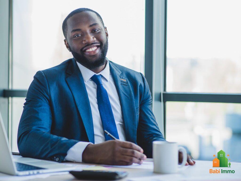 Conseiller financier en costume expliquant les conditions d’un crédit immobilier en Côte d’Ivoire - Obtenir un crédit immobilier reste un défi en Côte d’Ivoire : les conditions réelles en 2025.